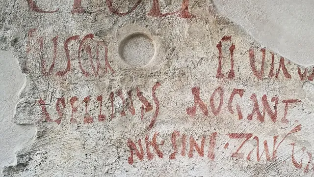 Red painted letters on plaster from Pompeii, reading ASELLINAS ROGANT.